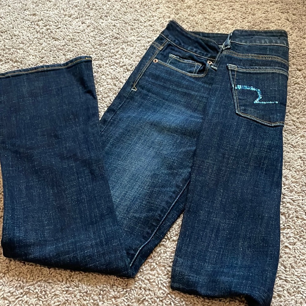 American Eagle Stretch Jeans with a Sparkly Emblem on back pockets.